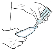 Un hombre pone lubricante a base de agua sobre el condón en el pene erecto.