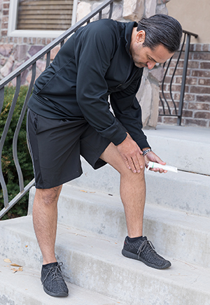 Hombre poniéndose pomada en la rodilla antes de hacer ejercicio físico.