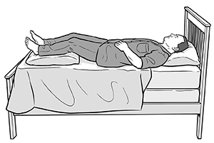 Hombre acostado boca arriba en la cama con almohadas debajo de las piernas.